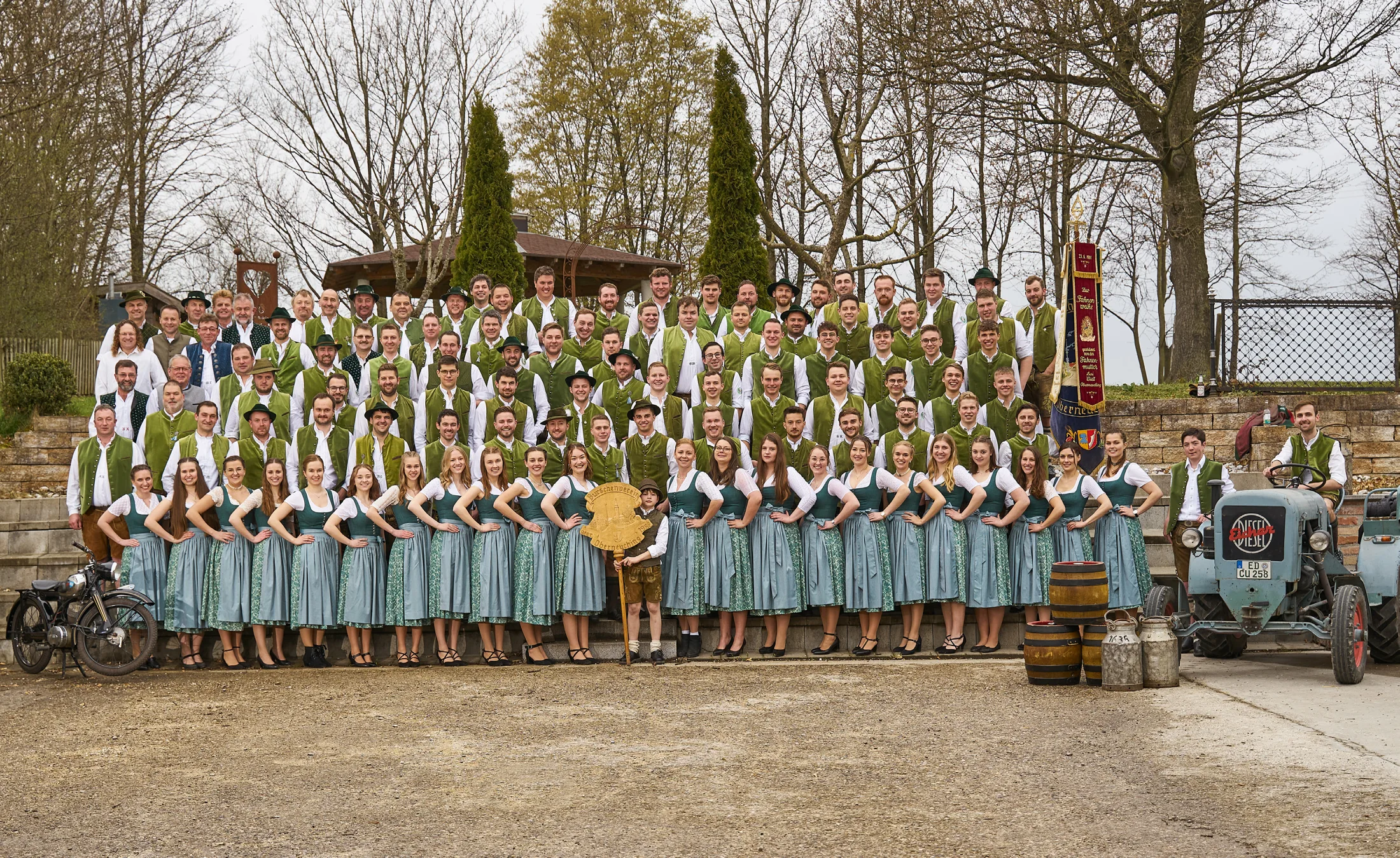Historisches Gruppenbild der Burschen und Festdamen mit Vereinsfahne und Traktor aus der Festschrift 2023